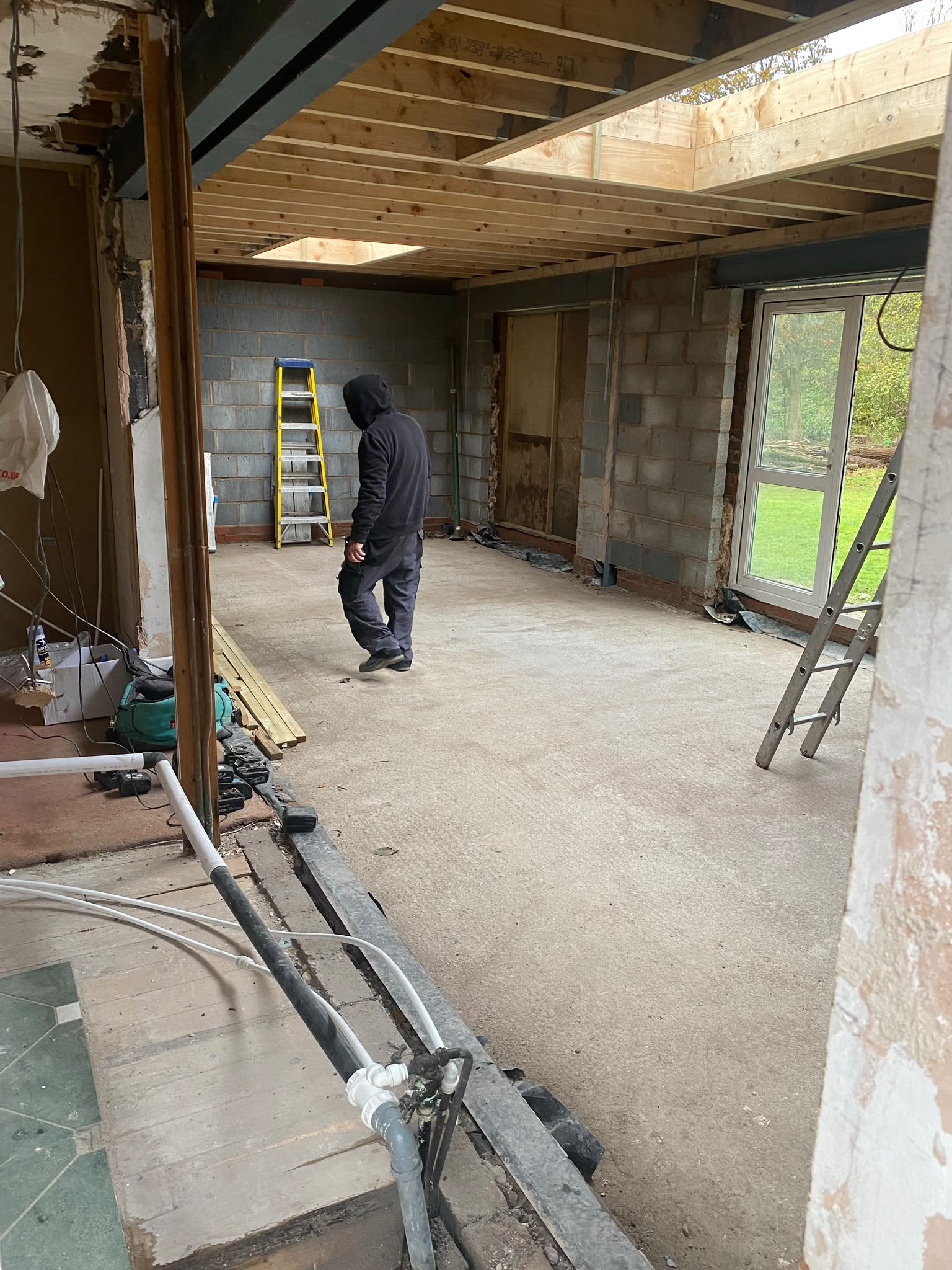 Rear extension shell with fresh timber joists, rooflight opening and steel beam in place